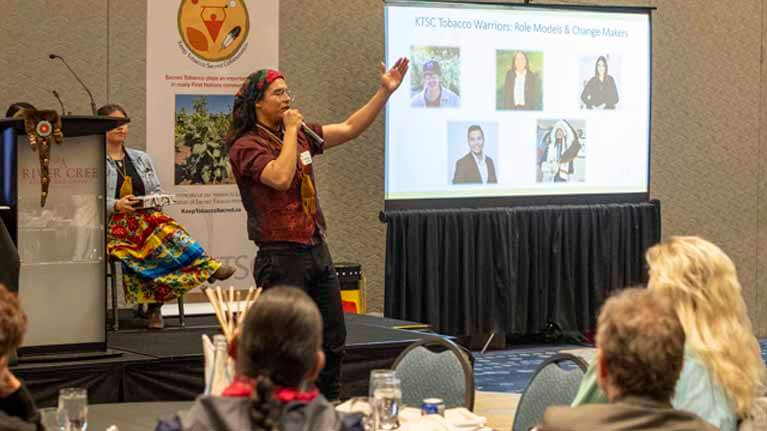 Tobacco Warrior Ethan Yellow Old Woman speaking to audience in a conference room.